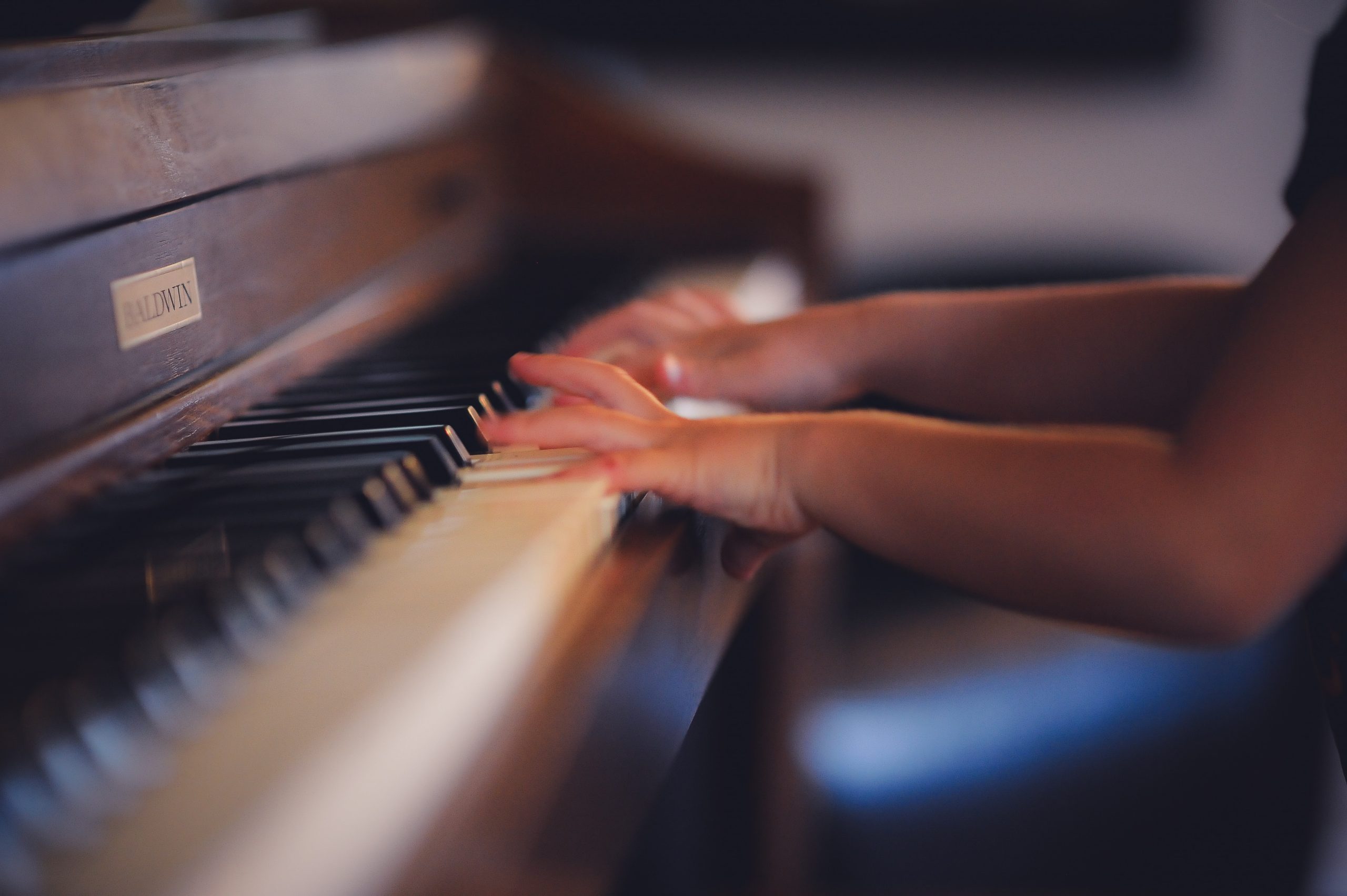 hands playing on a piano