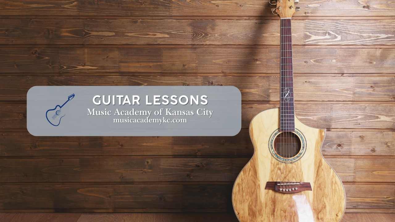 a guitar leaning against a wall next to a graphic that says guitar lessongs music academy of kansas city